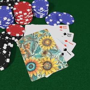 May include: A poker game scene with playing cards and poker chips. The cards have a sunflower design on the back and show a hand of tens. Stacks of red, blue, and black chips are on a green felt surface.