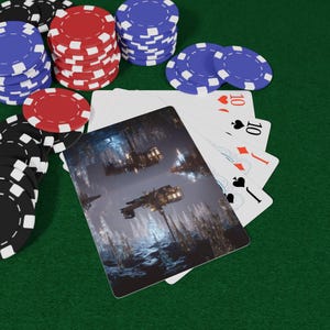 May include: A poker game scene with playing cards and poker chips. The cards show a futuristic space scene. Stacks of red, blue, and black and white poker chips are scattered around the cards on a green felt surface.