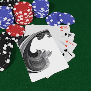 May include: Poker set with playing cards and poker chips. The cards feature a black and white wave design and the number 10. Stacks of red, blue, and black chips are visible on a green surface.