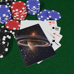May include: Poker set with playing cards and casino chips. The playing cards feature a space-themed design. Stacks of red, blue, and black chips are arranged on a green felt surface. The cards show the ten of hearts, diamonds, and spades.