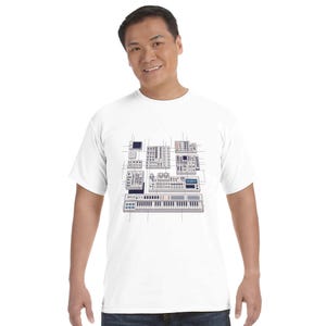 Puede incluir: Camiseta blanca con un gráfico de sintetizadores musicales y equipos de estudio. El diseño incluye un teclado, mezcladores y otros dispositivos electrónicos, todos representados en un estilo técnico detallado. La camiseta es de cuello redondo clásico.