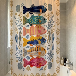 Puede incluir: Una cortina de ducha blanca con una pila vertical de seis peces coloridos en tonos azul oscuro, verde azulado, rosa, amarillo y rojo. El diseño incluye coral azul claro, bordes de algas color canela y varias conchas marinas dispersas.