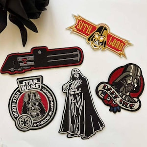 May include: Embroidered patches featuring Star Wars characters and logos. Designs include Darth Vader, a lightsaber, and the words "Sith Lord" and "Dark Side". Patches are black, red, and white.