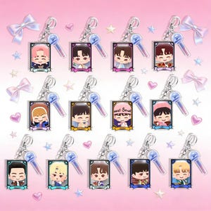 May include: Collection of character keychains with cartoon illustrations. Each keychain features a small, framed image of a character, a microphone charm, and a silver keyring. The background is pink with decorative bows, stars, and hearts.