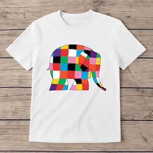 May include: White t-shirt with a vibrant elephant illustration. The elephant is made up of a patchwork design with squares of red, yellow, green, blue, and black. The tee has a round neck and short sleeves.