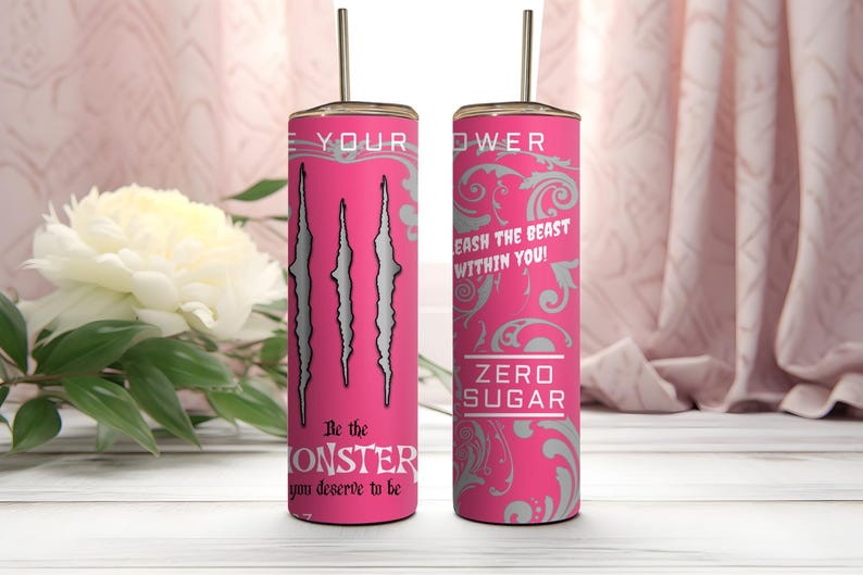 Może przedstawiać: Dwa cylindryczne r&oacute;żowe kubki z metalowymi słomkami. Jeden posiada trzy srebrne ślady pazur&oacute;w, napis "Be the MONSTER you deserve to be" oraz "LEASH THE BEAST WITHIN YOU!". Drugi przedstawia szary kwiatowy wz&oacute;r oraz napis "ZERO SUGAR."
