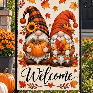 May include: A rectangular garden flag featuring two gnomes with white beards, one wearing a plaid hat with a sunflower and holding a pumpkin, the other in a solid orange hat holding autumn leaves, with the word Welcome in black script below.