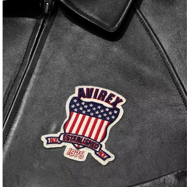 May include: A white ceramic mug with a black handle and the text "But First, Coffee" in a handwritten style. The mug is on a white surface. The mug is 4 inches tall.