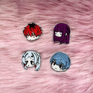 Könnte beinhalten: Vier gestickte Aufnäher mit stilisierten Anime-Charakterköpfen. Ein Aufnäher hat stachelige rote Haare, einer hat langes violettes Haar, einer hat hellblaues Haar mit zwei Zöpfen und einer hat kurzes blaues Haar. Jeder hat markante Gesichtszüge.