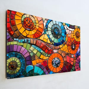 May include: A vibrant mosaic artwork featuring a colorful abstract design. The mosaic is composed of small, irregularly shaped tiles in shades of red, orange, yellow, green, blue, and purple, arranged in swirling patterns.