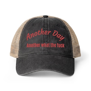 Può includere: Cappellino da camionista nero con retro in rete beige e visiera curva. Il cappellino presenta il testo rosso "Another Day" sopra "Another what the fuck". Il cappellino ha un aspetto vintage.