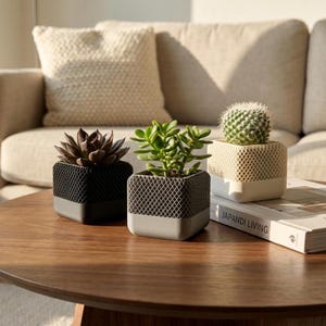 Può includere: Un set di tre tazze in ceramica con finitura opaca e macchiettata. Le tazze sono nei toni del crema, grigio chiaro e grigio scuro. Ogni tazza ha un design semplice e minimalista.