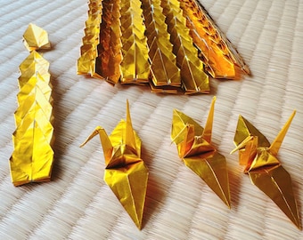 Set of 100 golden origami cranes for weddings and decorations.