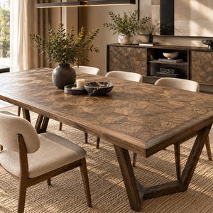 Puede incluir: Una mesa de comedor rectangular de madera con un patrón de parqué geométrico en el tablero y una base angular robusta, acompañada de cuatro sillas con asientos tapizados en beige claro y respaldos curvos de madera en tono marrón cálido.