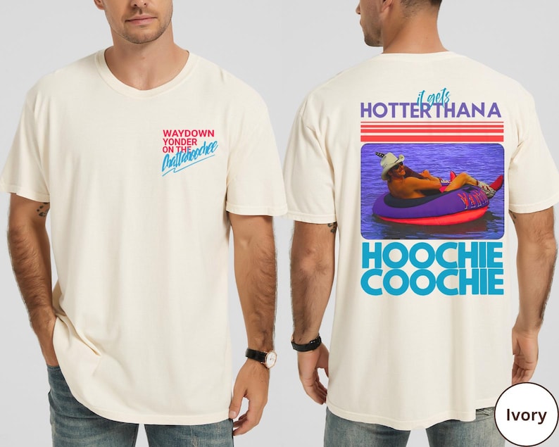 May include: Ivory-colored t-shirt with text on the front and back. The front reads "WAYDOWN YONDER ON THE Chattanooga". The back features a graphic of a person in a tube with the text "it gets HOTTER THANA HOOCHIE COOCHIE".