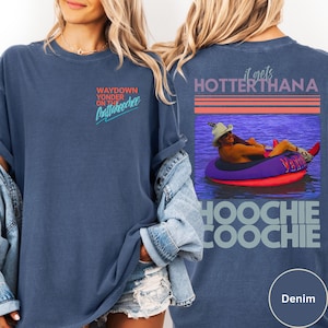 May include: Denim blue t-shirt with the text "Waydown Yonder on the Chattahoochee" on the front. The back features a graphic of a person in a tube with the text "it gets HOTTER THANA Hoochie Coochie".