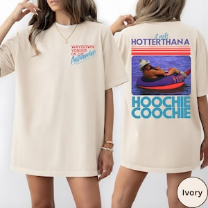 May include: Ivory-colored t-shirt with the text "Waydown Yonder on the Chattahoochee" on the front. The back features a graphic of a person in a tube with the text "It gets Hotter Thana Hoochie Coochie".