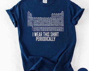 May include: Navy blue t-shirt featuring a periodic table of elements design. The shirt has the text "I WEAR THIS SHIRT PERIODICALLY" in white. The shirt is made of a soft material and is a comfortable fit.