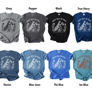 May include: A collection of eight short-sleeved crew neck t-shirts in various colours including grey, pepper, black, navy, denim, blue jean, flo blue, and ice blue. Each shirt features a graphic of a praying mantis with the text Girls Will Be Girls.