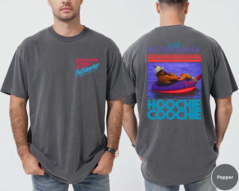 May include: Pepper-colored t-shirt with front text reading "WAYDOWN YONDER ON Chattahoochee" in red and blue. The back features a graphic of a person in a tube with the text "I AM HOTTER THAN A HOOCHIE COOCHIE".