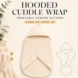 May include: A cream-coloured hooded cuddle wrap shown as a printable sewing pattern. The text reads HOODED CUDDLE WRAP PRINTABLE SEWING PATTERN 3 SIZES A4 LETTER A0. A technical line drawing of the pattern pieces is displayed on the right side.