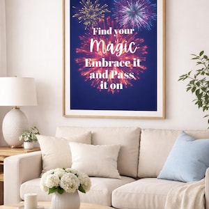 以下が含まれることがあります： 「Find your magic, Embrace it and Pass it on」の文字が書かれた、カラフルな花火が描かれた濃い青色の背景の額入りプリント。ベージュのソファと白いクッション、木製のコーヒーテーブルの上に飾られています。