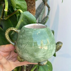 Handmade ceramic mug featuring a turtle design