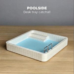 Op de afbeelding: Een vierkante bureau-opbergbak ontworpen als een zwembad, met witte tegelwanden, een lichtblauwe binnenkant, een witte trap en een kleine zilverkleurige metalen ladder. De tekst POOLSIDE Desk tray catchall is zichtbaar op de afbeelding.