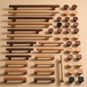 May include: A collection of wooden cabinet hardware, including various sizes of pulls and knobs. The pulls are rectangular with rounded edges, and the knobs are round and square. The wood tones range from light to dark brown.