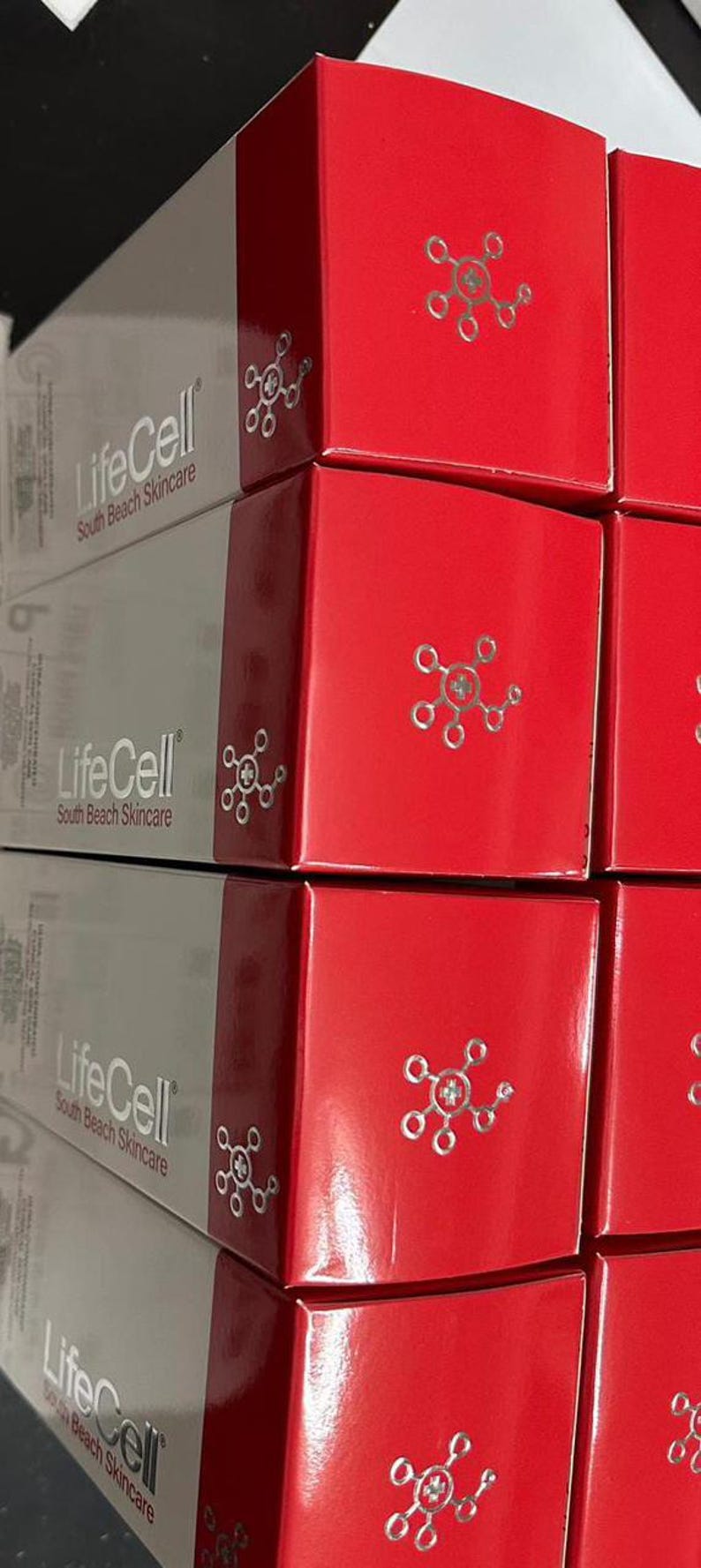 May include: Stacked boxes of LifeCell South Beach Skincare products. The boxes are red and gray, with the brand name and logo printed on them. The boxes have a glossy finish.