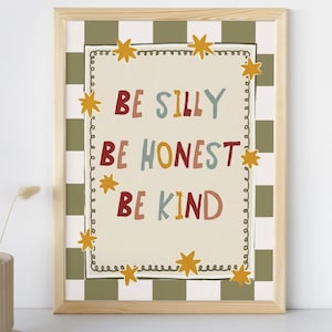 Può includere: Una stampa artistica incorniciata con le parole "BE SILLY BE HONEST BE KIND" in lettere colorate. La stampa ha uno sfondo color crema con un bordo decorativo e accenti di stelle. Lo sfondo è un motivo a scacchi verdi e bianchi.