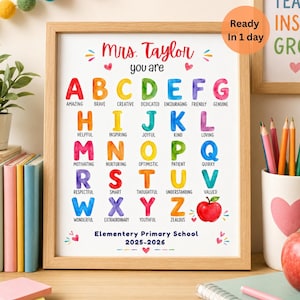 May include: A framed educational poster featuring the text Mrs. Taylor you are followed by the alphabet in colorful watercolor letters, each paired with a positive adjective. The bottom includes Elementary Primary School 2025-2026 and a red apple.