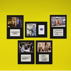 May include: A collection of five black-framed wall displays featuring photographic scenes from the television show Friends, each paired with a white card containing printed dialogue from the episodes, arranged on a solid yellow wall surface.