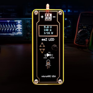 May include: A black and yellow eez LED device with a small screen displaying voltage and resistance readings. The device has buttons and a diagram of a diode. The text "microARC USA" is at the bottom.