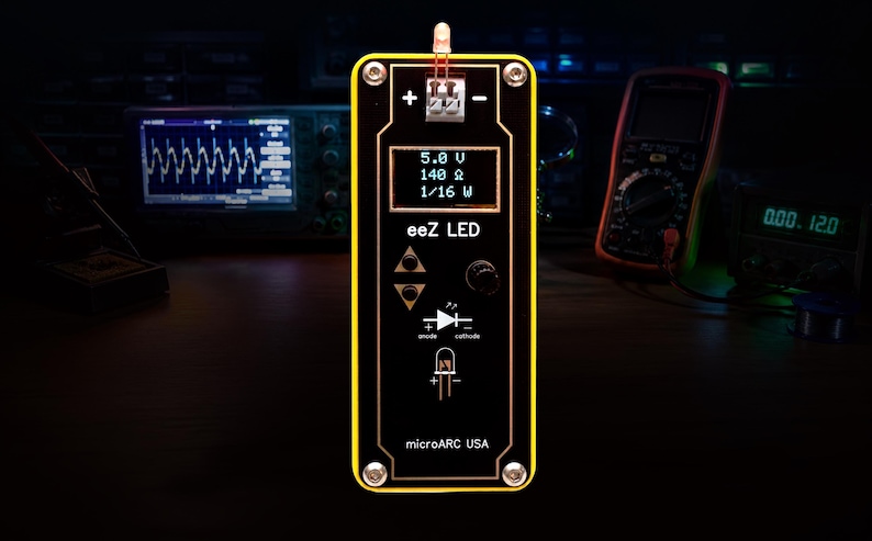 May include: A black and yellow eez LED device with a small screen displaying voltage and resistance readings. The device has buttons and a diagram of a diode. The text "microARC USA" is at the bottom.