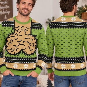 May include: A long-sleeve knit jumper featuring a green and tan colour scheme with a black and white geometric pattern. The front displays a large tan brain graphic, while the back and sleeves feature a repeating pattern of white snowflakes.