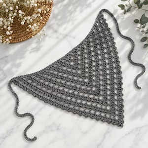 May include: A triangular dark gray crochet bandana featuring an openwork lattice pattern with a scalloped edge and long thin ties at the two top corners. The accessory is constructed with a repeating geometric stitch design throughout the fabric.