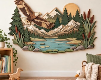 Könnte beinhalten: Ein mehrschichtiges Wandbild aus Holz, das eine Landschaft mit einem fliegenden Weißkopfseeadler, schneebedeckten Bergen, einem Nadelwald, einem See mit Seerosen und Schilf zeigt. Das Motiv enthält zudem eine große Sonne.