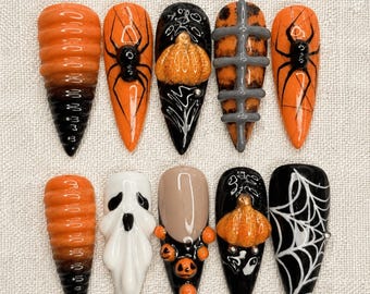 Könnte beinhalten: Ein Set aus zehn künstlichen Fingernägeln mit Halloween-Motiven, darunter orange-schwarze Farbverläufe, schwarze Spinnen auf Orange, ein 3D-Kürbis auf Schwarz, ein grauer Brustkorb, ein weißes Gespenst und ein weißes Spinnennetz auf Schwarz.