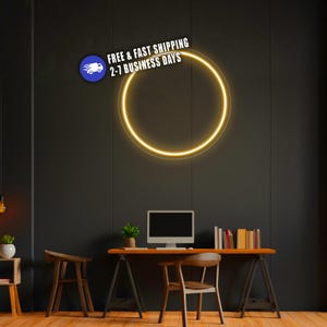 May include: A circular neon light fixture emitting a bright yellow glow mounted on a dark wall. The light forms a simple ring shape, providing a focused illumination against the dark background, creating a clean and modern visual effect.