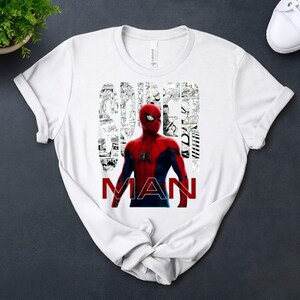 Peut inclure: Un t-shirt blanc &agrave; manches courtes avec un graphisme de Spider-Man en costume rouge et bleu. Le mot SPIDER est &eacute;crit dans une police en collage de cases de bande dessin&eacute;e noir et blanc, et le mot MAN est imprim&eacute; en lettres rouges majuscules.