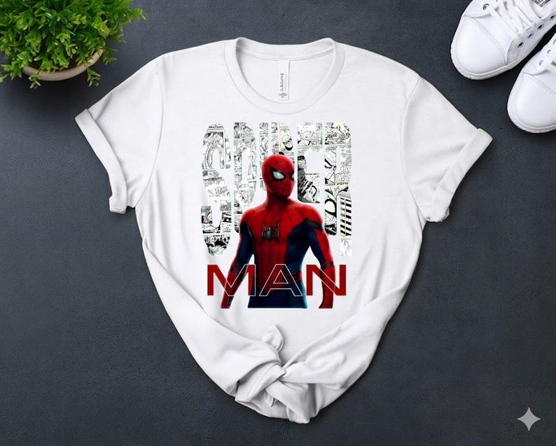Peut inclure: Un t-shirt blanc &agrave; manches courtes avec un graphisme de Spider-Man en costume rouge et bleu. Le mot SPIDER est &eacute;crit dans une police en collage de cases de bande dessin&eacute;e noir et blanc, et le mot MAN est imprim&eacute; en lettres rouges majuscules.