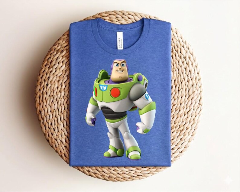 May include: A blue t-shirt featuring a graphic of Buzz Lightyear from Toy Story. The character is depicted in his signature green, white, and purple spacesuit. The shirt is made of a soft material and is suitable for casual wear.