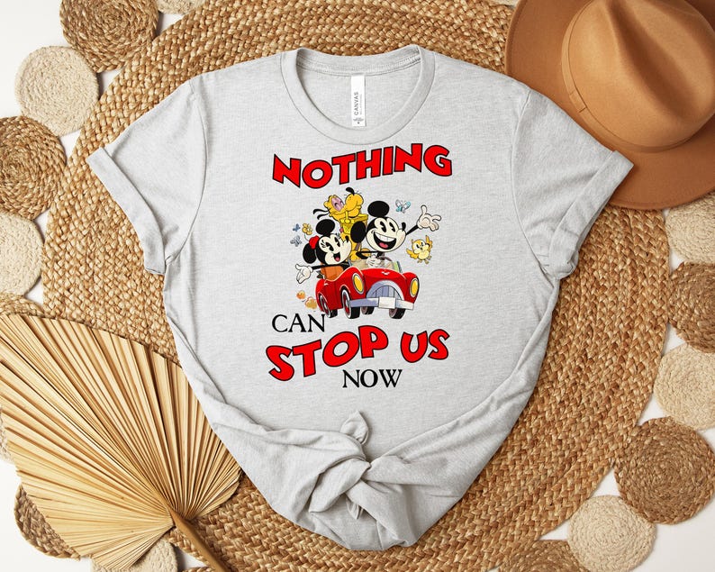 Puede incluir: Camiseta gris claro con una imagen de dibujos animados de Mickey y Minnie Mouse en un coche rojo, con el texto "NOTHING CAN STOP US NOW" en rojo. La camiseta es de material suave y tiene mangas cortas.