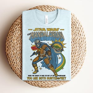 K&ouml;nnte beinhalten: Eine wei&szlig;e Keramik-Tasse mit schwarzem Henkel und dem Text "But First, Coffee" in fetter, schwarzer Schrift. Die Tasse steht vor einem verschwommenen Hintergrund, der eine gem&uuml;tliche Umgebung suggeriert.