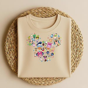 May include: A white ceramic mug with a black handle and the text "But First, Coffee" in a bold, black font. The mug is set against a blurred background, suggesting a cosy setting.