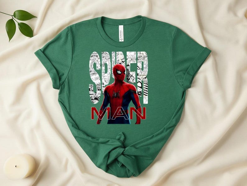 Peut inclure: Un t-shirt &agrave; manches courtes vert for&ecirc;t avec un graphisme du personnage Spider-Man en costume rouge et bleu. Le mot SPIDER est imprim&eacute; en blanc sur un fond de bande dessin&eacute;e, et le mot MAN est imprim&eacute; en lettres rouges grasses en dessous.