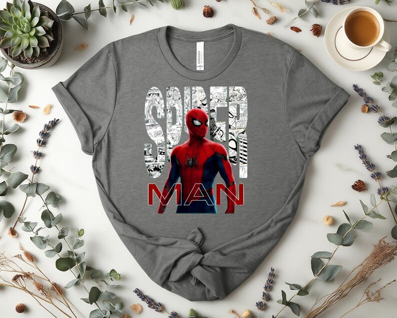 Peut inclure: Un t-shirt gris fonc&eacute; &agrave; manches courtes avec un motif du personnage Spider-Man en rouge et bleu. Le mot SPIDER est imprim&eacute; en blanc sur un fond de cases de bande dessin&eacute;e, et le mot MAN est imprim&eacute; en lettres rouges grasses en dessous.