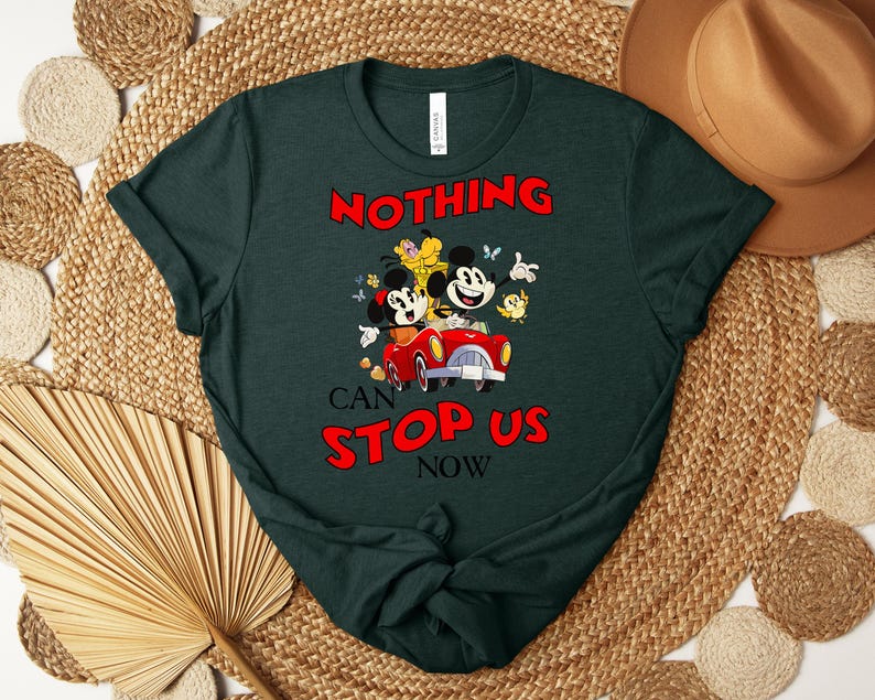 Puede incluir: Camiseta verde oscuro con un dise&ntilde;o de dibujos animados de Mickey y Minnie Mouse en un coche rojo, con el texto "NOTHING CAN STOP US NOW" en rojo. La camiseta tiene cuello redondo y mangas cortas.