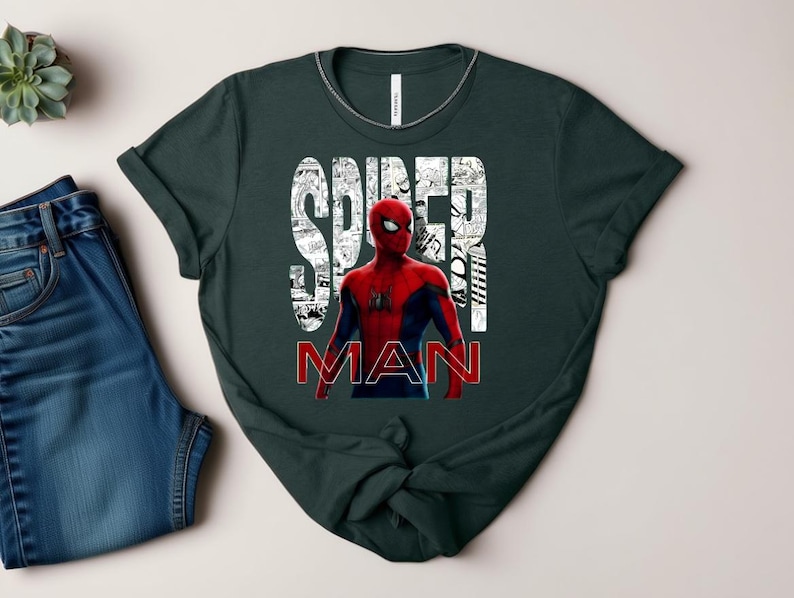 Peut inclure: Un t-shirt &agrave; manches courtes vert fonc&eacute; avec un graphisme de Spider-Man en costume rouge et bleu. Le mot SPIDER est imprim&eacute; en grandes lettres blanches remplies de cases de bande dessin&eacute;e, et le mot MAN est imprim&eacute; en dessous en lettres rouges.